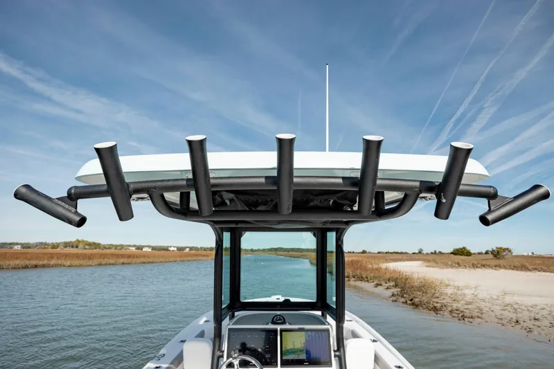 Slide: The Image of 2024 Caymas 281 HB boat with rod holders on a calm waterway. - 27