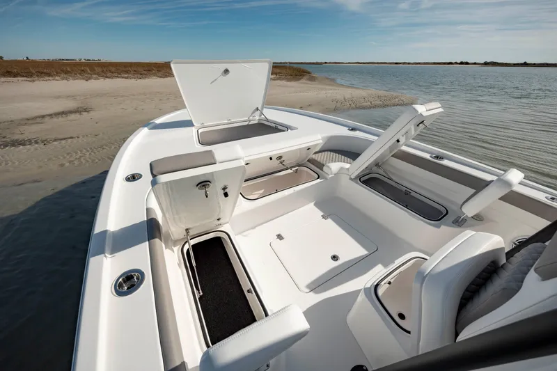 Slide: The Image of 2024 Caymas 281 HB boat with open storage compartments on a sandy shore. - 32