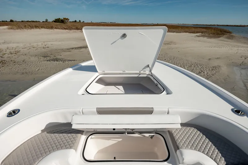 Slide: The Image of 2024 Caymas 281 HB boat with open storage compartments on a sandy shore. - 34
