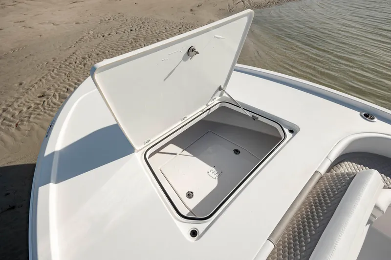 Slide: The Image of 2024 Caymas 281 HB boat storage compartment open on deck near water. - 35