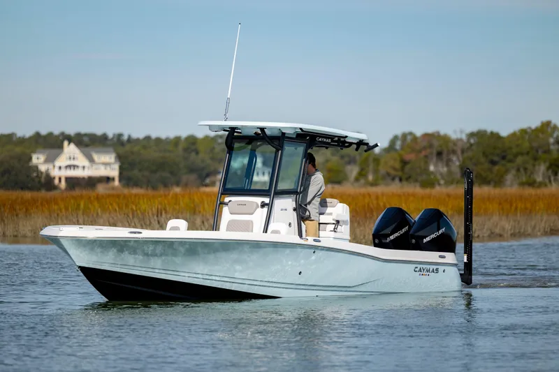 Slide: The Image of 2024 Caymas 281 HB boat cruising on a calm lake with scenic background. - 6