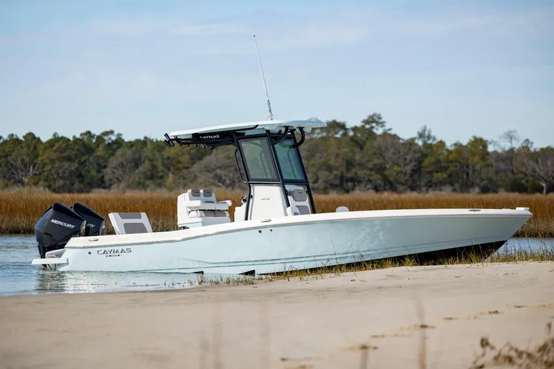Slide: The Image of 2024 Caymas 281 HB boat docked on a sandy shore with scenic background. - 8