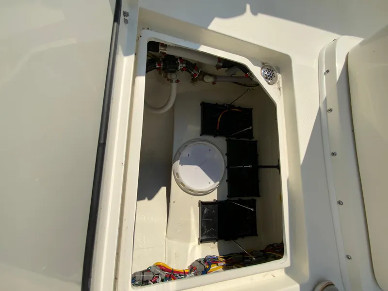 Slide: The Image of 2025 Cobia 265 CC boat storage compartment with wiring and components. - 18