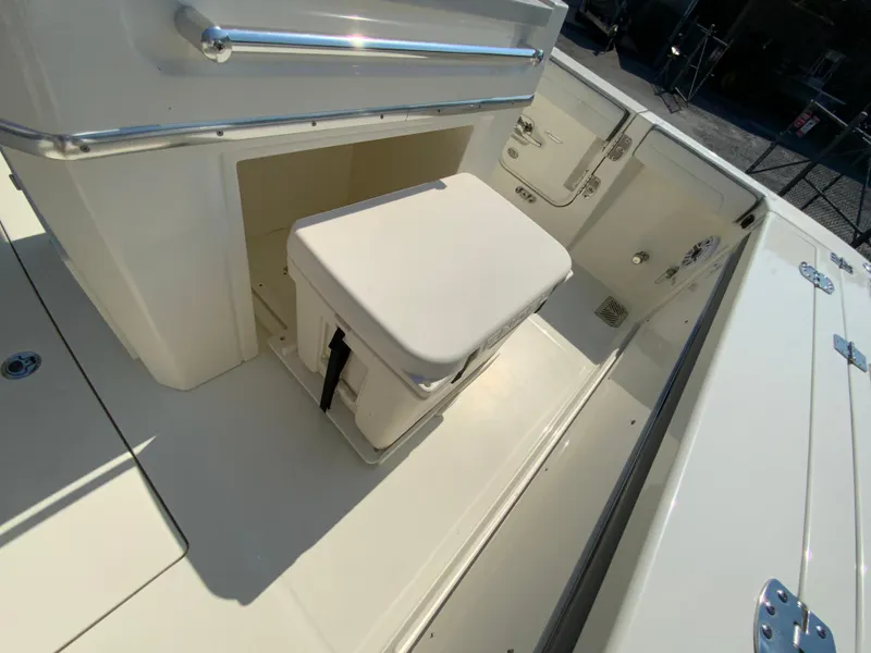 Slide: The Image of 2025 Cobia 265 CC boat interior with storage compartment and cushioned seat. - 19