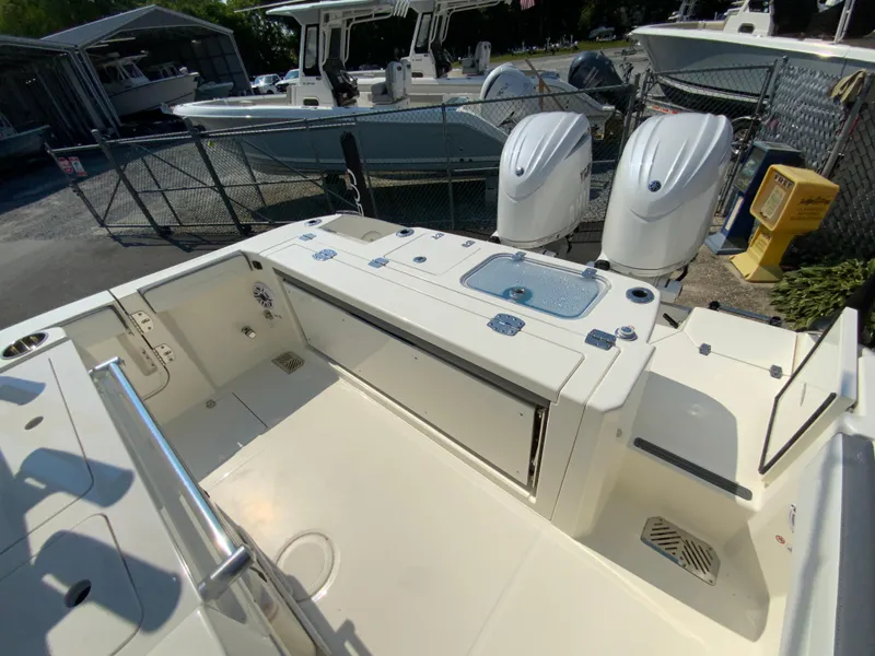 Slide: The Image of 2025 Cobia 265 CC boat with dual outboard engines, spacious deck, and storage compartments. - 20