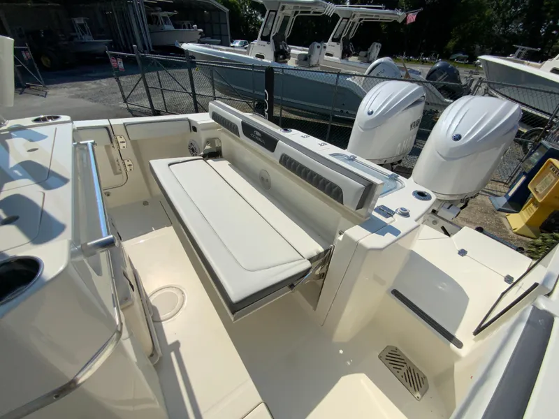 Slide: The Image of 2025 Cobia 265 CC boat interior with seating and dual outboard engines. - 21
