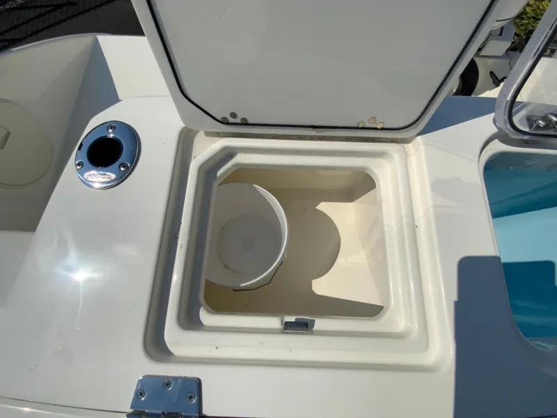 Slide: The Image of 2025 Cobia 265 CC boat storage compartment with open lid. - 24