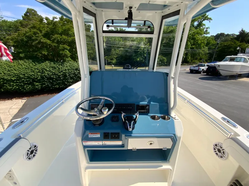 Slide: The Image of 2025 Cobia 265 CC center console boat with steering wheel and control panel. - 26