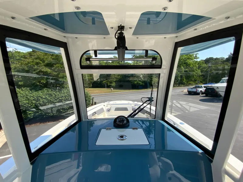 Slide: The Image of 2025 Cobia 265 CC boat cockpit with windshield and dashboard. - 28