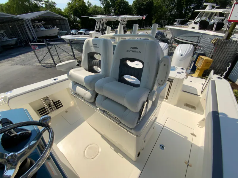 Slide: The Image of 2025 Cobia 265 CC boat interior with dual captain's chairs and steering wheel. - 29