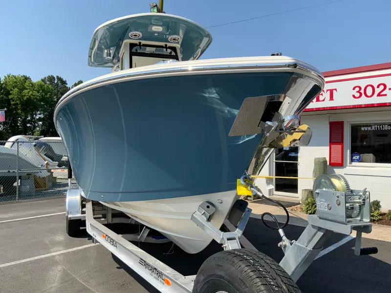 Slide: The Image of 2025 Cobia 265 CC boat on a trailer in a dealership lot. - 3