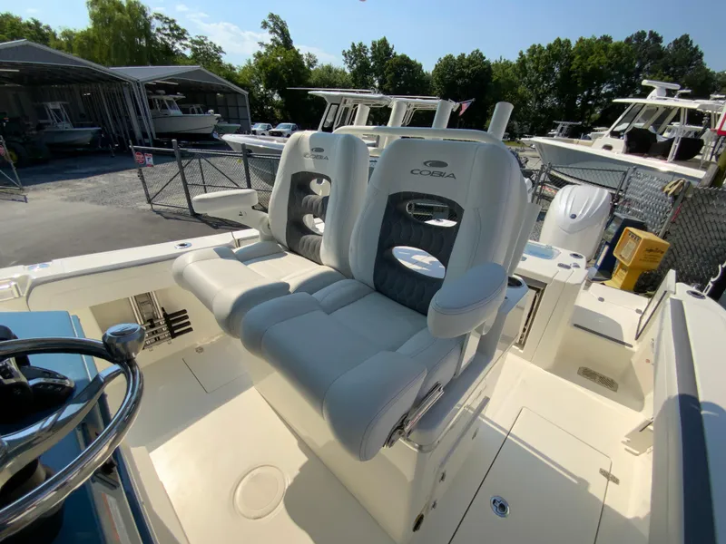 Slide: The Image of 2025 Cobia 265 CC boat with dual captain's chairs and modern helm station. - 30