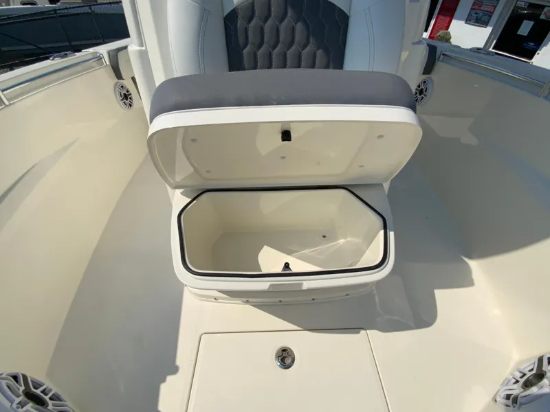 Slide: The Image of 2025 Cobia 265 CC boat with open storage compartment and cushioned seating. - 43