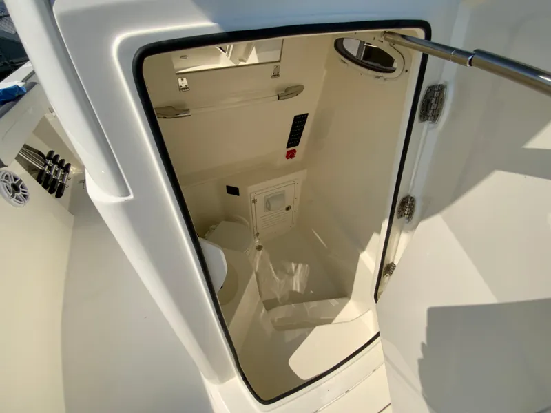 Slide: The Image of 2025 Cobia 265 CC boat interior cabin with toilet and storage. - 47