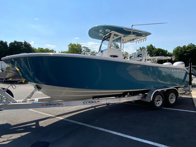 Slide: The Image of 2025 Cobia 265 CC boat on a trailer in a parking lot. - 6