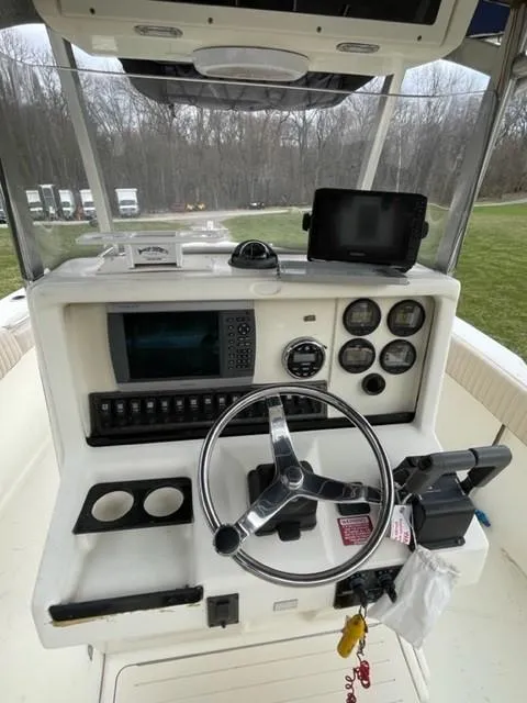 Slide: The Image of 2003 Scout 280 Sportfish boat dashboard with steering wheel, gauges, and navigation equipment. - 11