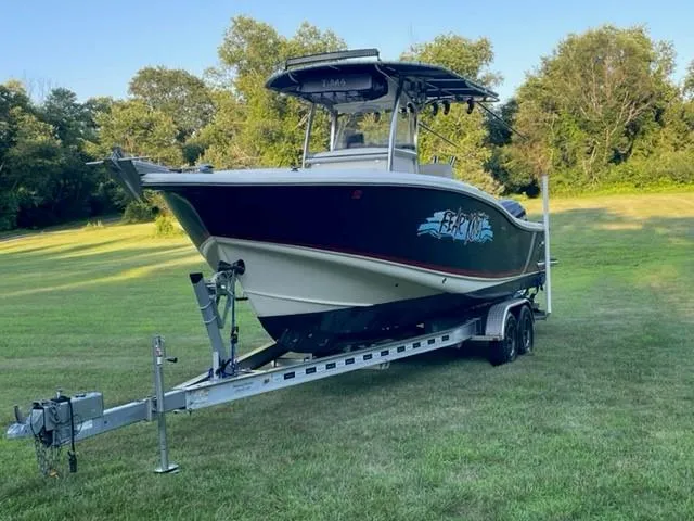 Slide: The Image of 2003 Scout 280 Sportfish boat on trailer in grassy field. - 2