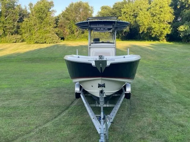 Slide: The Image of 2003 Scout 280 Sportfish boat on trailer, parked on grassy field with trees in background. - 3