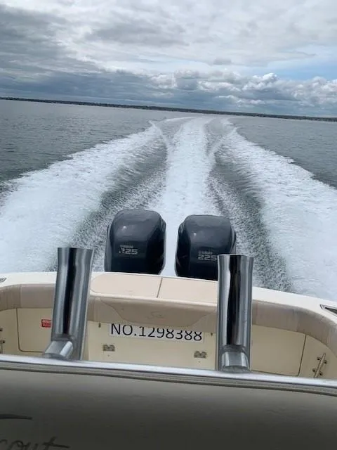 Slide: The Image of 2003 Scout 280 Sportfish boat with twin engines cruising on open water. - 4