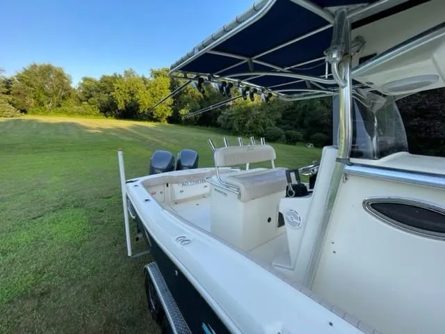Slide: The Image of 2003 Scout 280 Sportfish boat with canopy, parked on grassy field. - 9