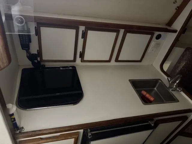 Slide: The Image of 1992 Blackfin 29 Combi boat interior with kitchenette, sink, and storage cabinets. - 15