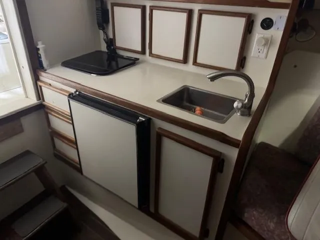 Slide: The Image of Compact kitchen area in a 1992 Blackfin 29 Combi boat with sink and stove. - 17