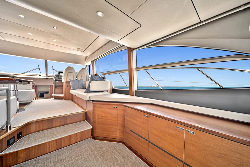 Slide: The Image of 2020 Princess F55 Flybridge yacht interior with modern wood cabinetry and panoramic windows. - 18