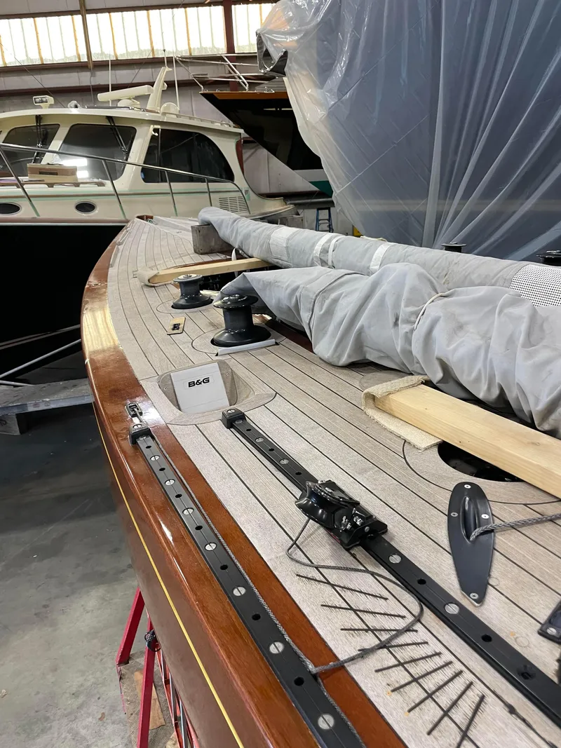 Slide: The Image of 1989 Litton International 6 Metre sailboat deck in storage, featuring rigging and covered sails. - 6