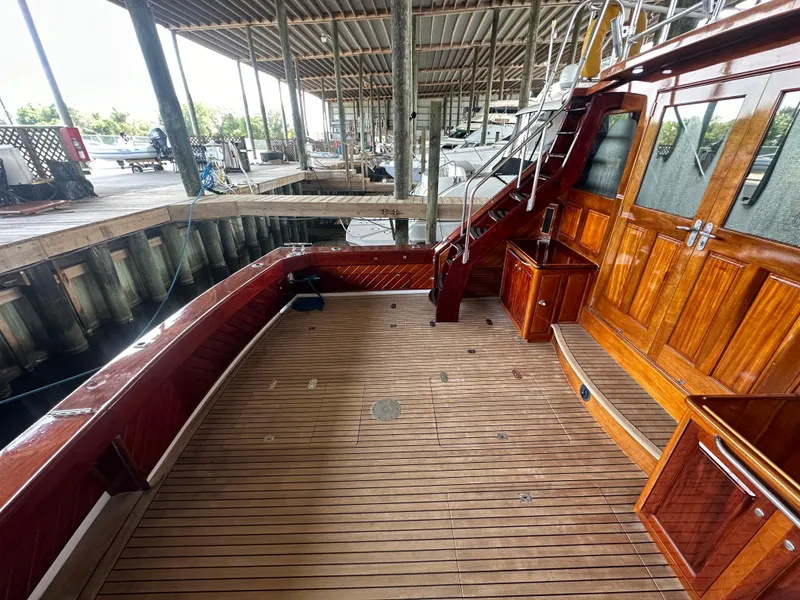 Slide: The Image of 1980 Bertram 58 Convertible Custom yacht with wooden deck and cabin, docked in marina. - 11