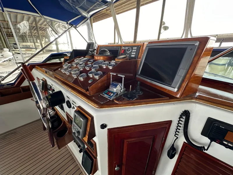 Slide: The Image of 1980 Bertram 58 Convertible Custom yacht helm with navigation instruments and wooden paneling. - 17