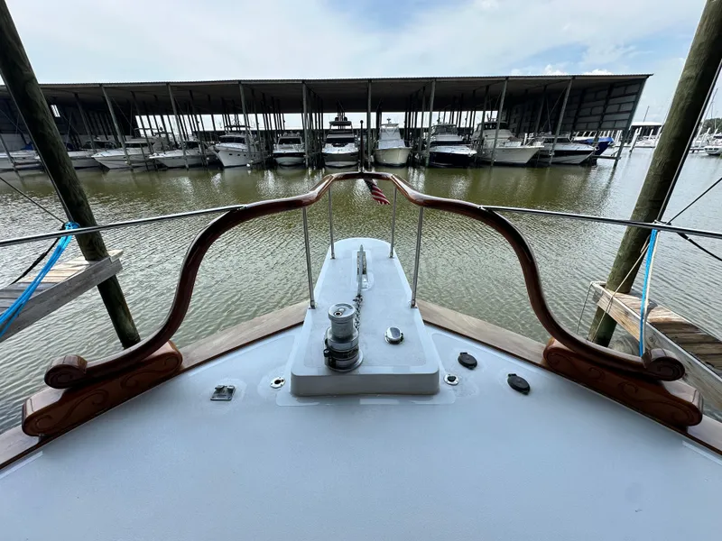 Slide: The Image of 1980 Bertram 58 Convertible Custom yacht docked at marina, view from bow. - 26