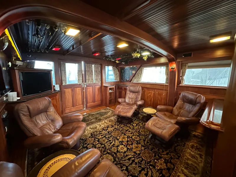 Slide: The Image of Luxurious interior of a 2010 Bertram 58 Convertible yacht with leather seating and wood paneling. - 44