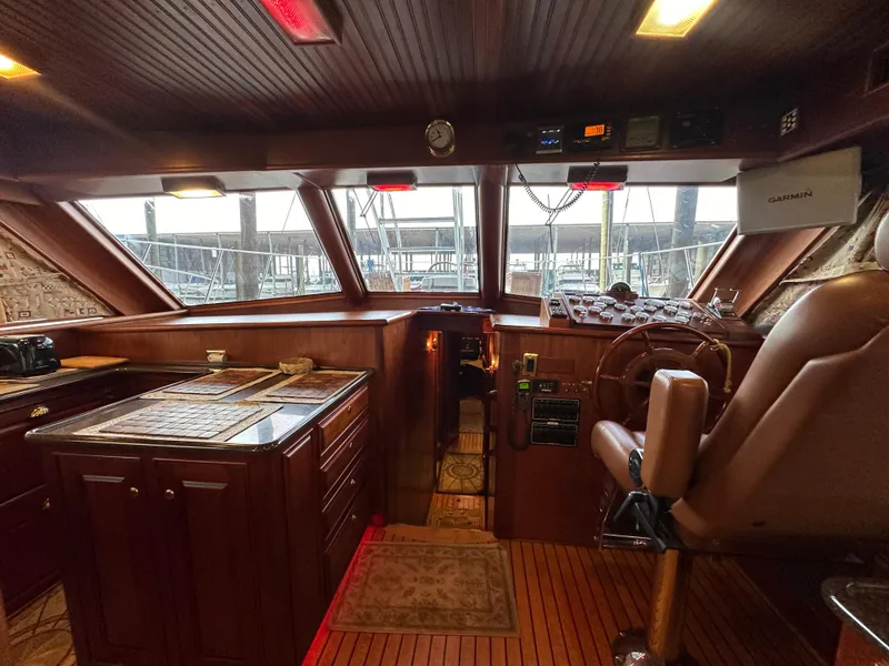 Slide: The Image of Interior of a 2010 Bertram 58 Convertible yacht, featuring a wooden helm and navigation area. - 48