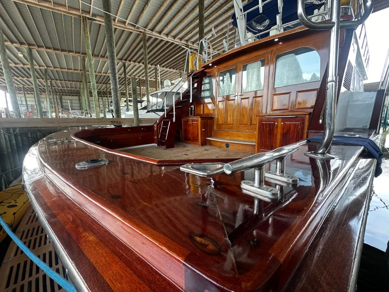 Slide: The Image of 1980 Bertram 58 Convertible Custom yacht with polished wood deck in marina. - 10