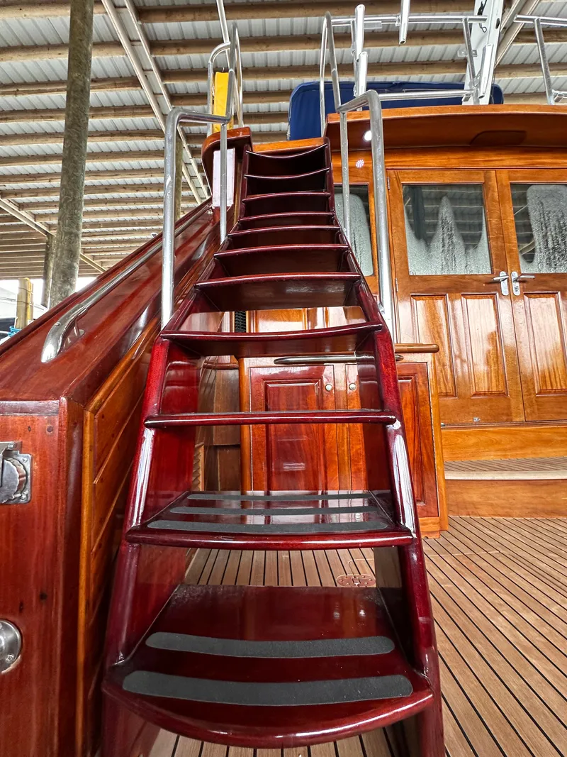 Slide: The Image of Staircase on 1980 Bertram 58 Convertible Custom yacht with polished wood finish. - 13