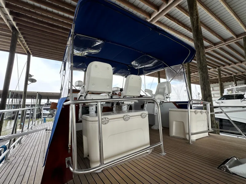 Slide: The Image of 1980 Bertram 58 Convertible Custom yacht interior with seating under blue canopy. - 14