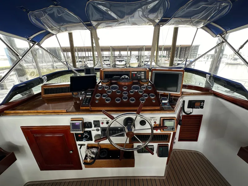 Slide: The Image of 1980 Bertram 58 Convertible Custom yacht helm with classic wooden dashboard and modern navigation equipment. - 16