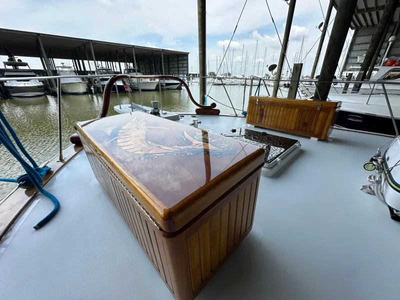 Slide: The Image of 1980 Bertram 58 Convertible Custom yacht deck with wooden storage and marina view. - 25