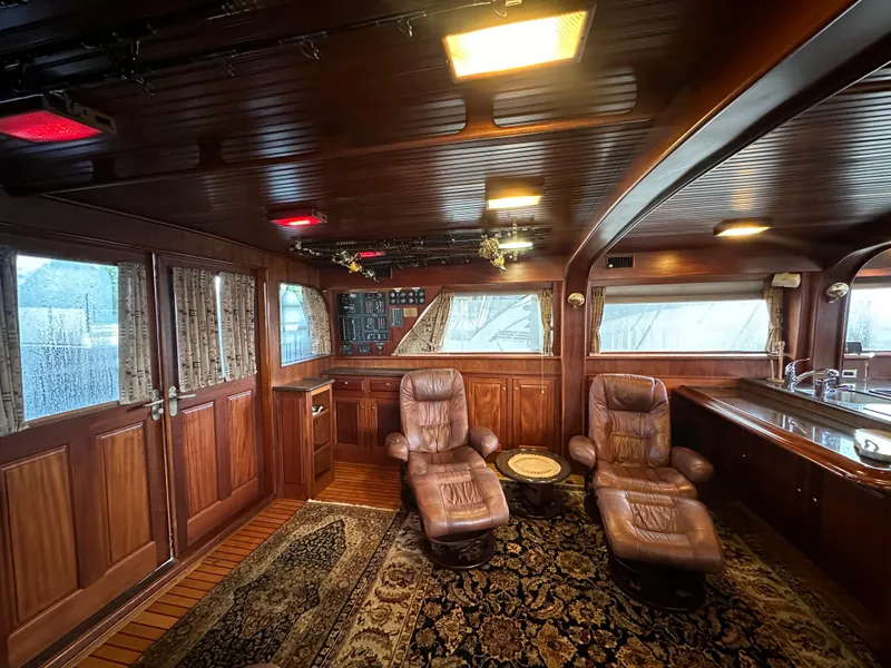 Slide: The Image of Luxurious interior of 1980 Bertram 58 Convertible Custom yacht with leather chairs and wood paneling. - 39
