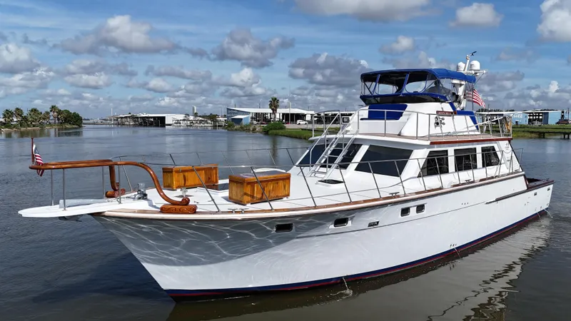 Slide: The Image of 1980 Bertram 58 Convertible Custom yacht on calm water, under a partly cloudy sky. - 4