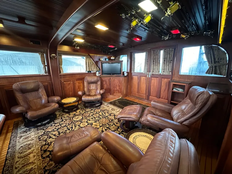 Slide: The Image of Luxurious 1980 Bertram 58 Convertible Custom yacht interior with leather seating and elegant wood paneling. - 40