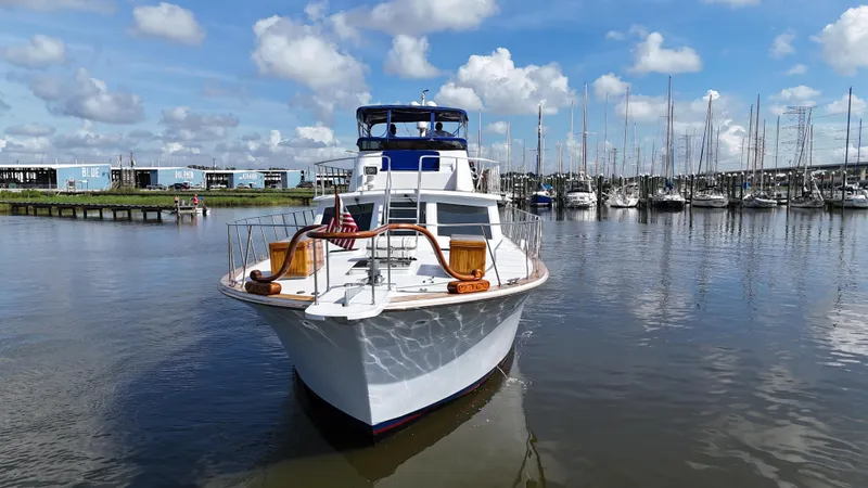 Slide: The Image of 1980 Bertram 58 Convertible Custom yacht docked in a marina under a blue sky. - 9