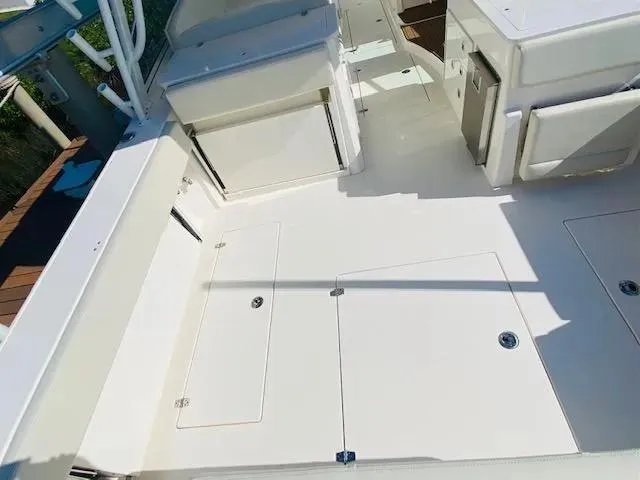 Slide: The Image of 2021 Cobia 330 Dual Console boat deck with storage compartments. - 17