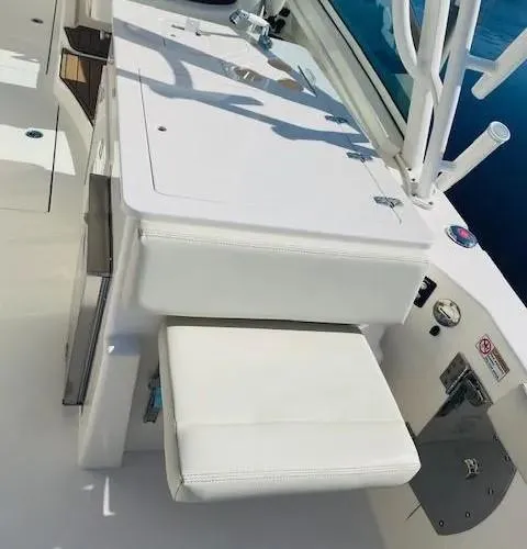 Slide: The Image of 2021 Cobia 330 Dual Console boat interior with white seating and storage. - 20