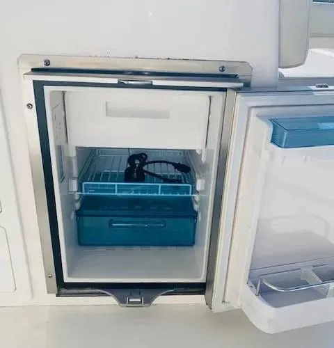 Slide: The Image of 2021 Cobia 330 Dual Console boat refrigerator with open door. - 22