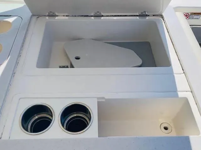 Slide: The Image of 2021 Cobia 330 Dual Console storage compartment and cup holders. - 23