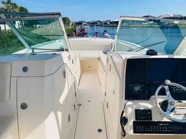 Slide: The Image of 2021 Cobia 330 Dual Console boat interior with steering wheel and open deck. - 24