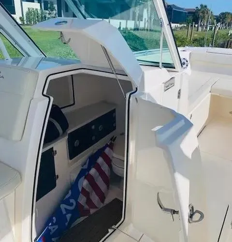 Slide: The Image of 2021 Cobia 330 Dual Console boat interior with open storage compartment. - 27