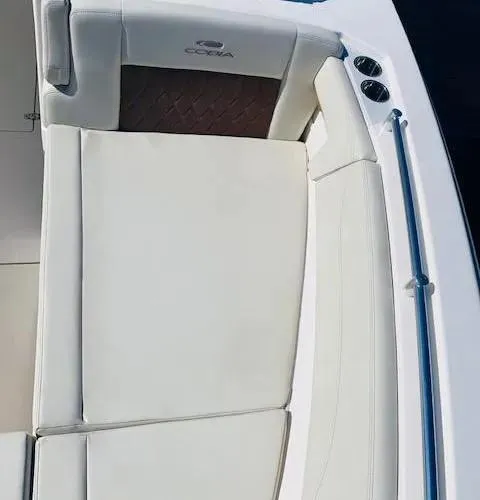 Slide: The Image of 2021 Cobia 330 Dual Console boat with white cushioned seating. - 28