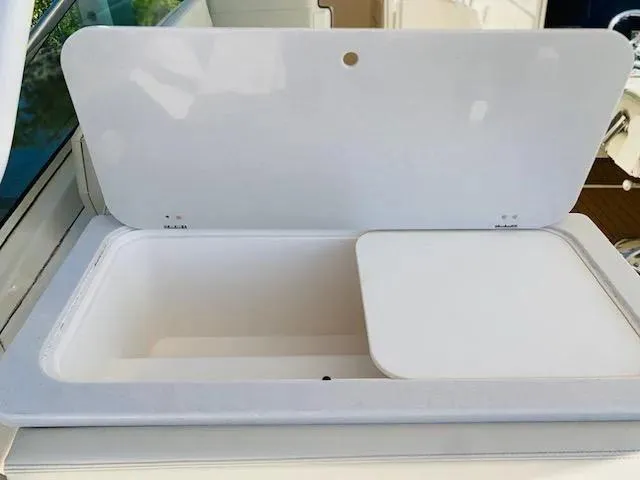 Slide: The Image of Open storage compartment on a 2021 Cobia 330 Dual Console boat. - 31